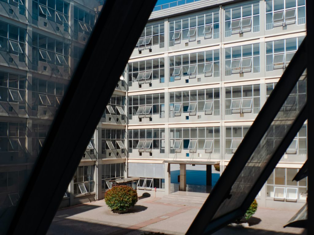 Modern building with many windows overlooking a sunny courtyard.