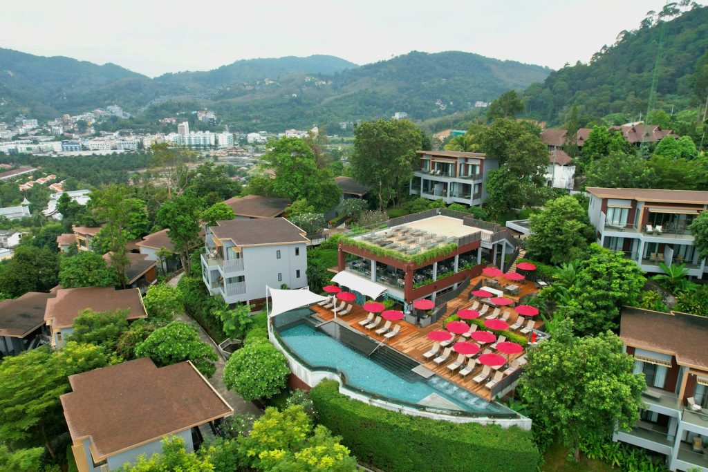 Luxury resort with infinity pool and lounge chairs on hillside.